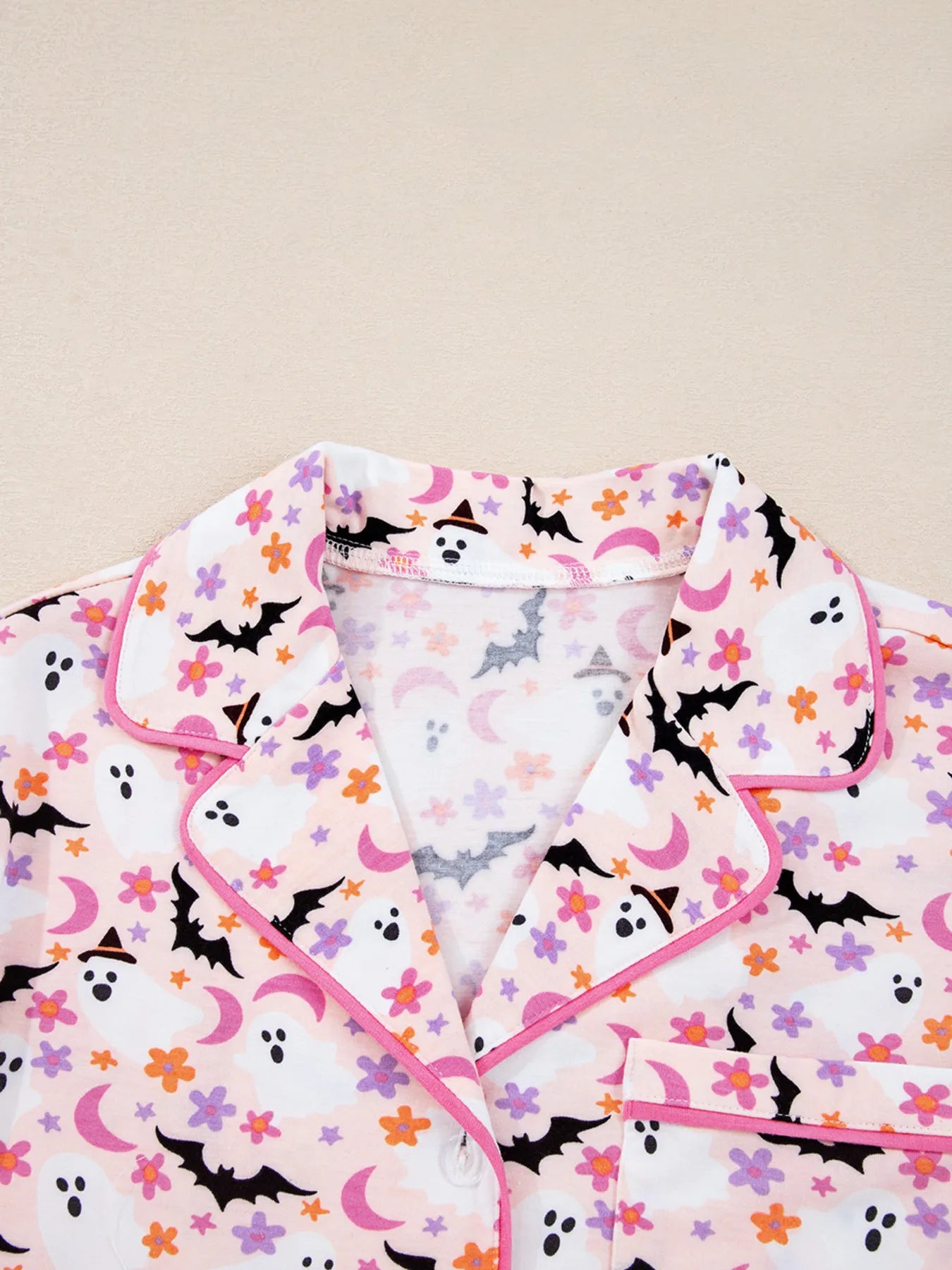 Detail of button-up top with chest pocket in ghost print