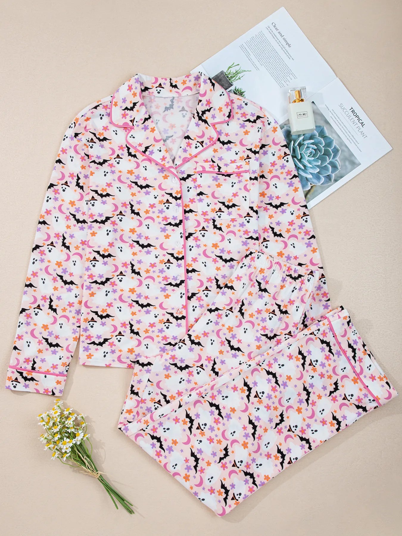 Floral patterned shirt on a beige surface with a magazine and flowers.
