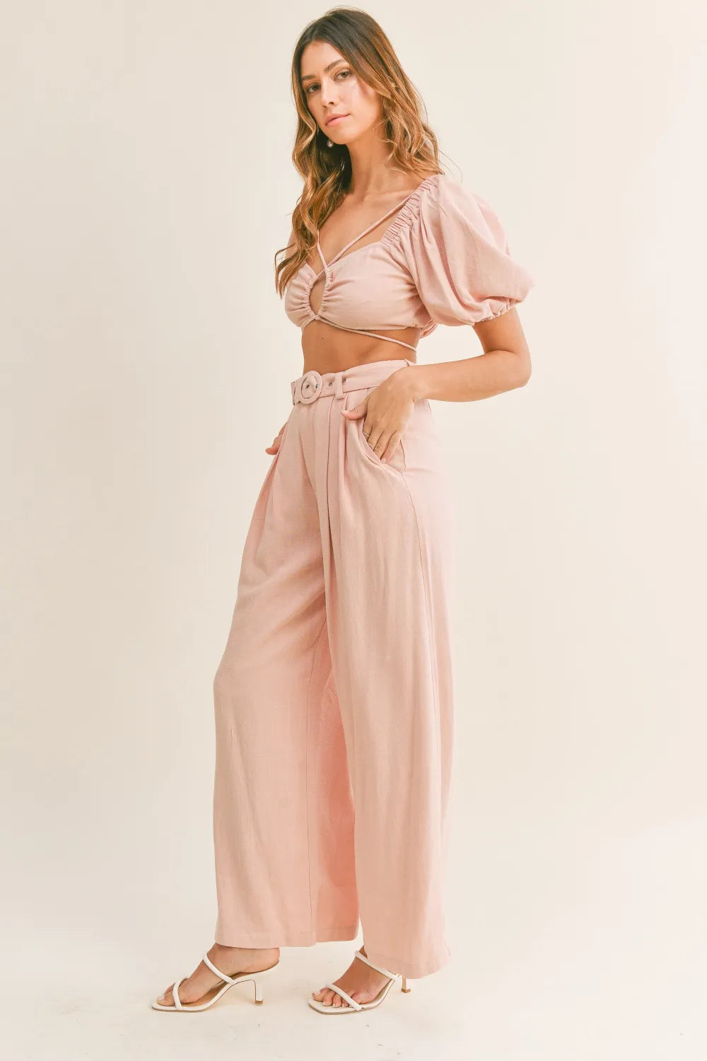 Imperio by Johana two-piece set featuring a cut-out crop top and wide-leg belted pants.
