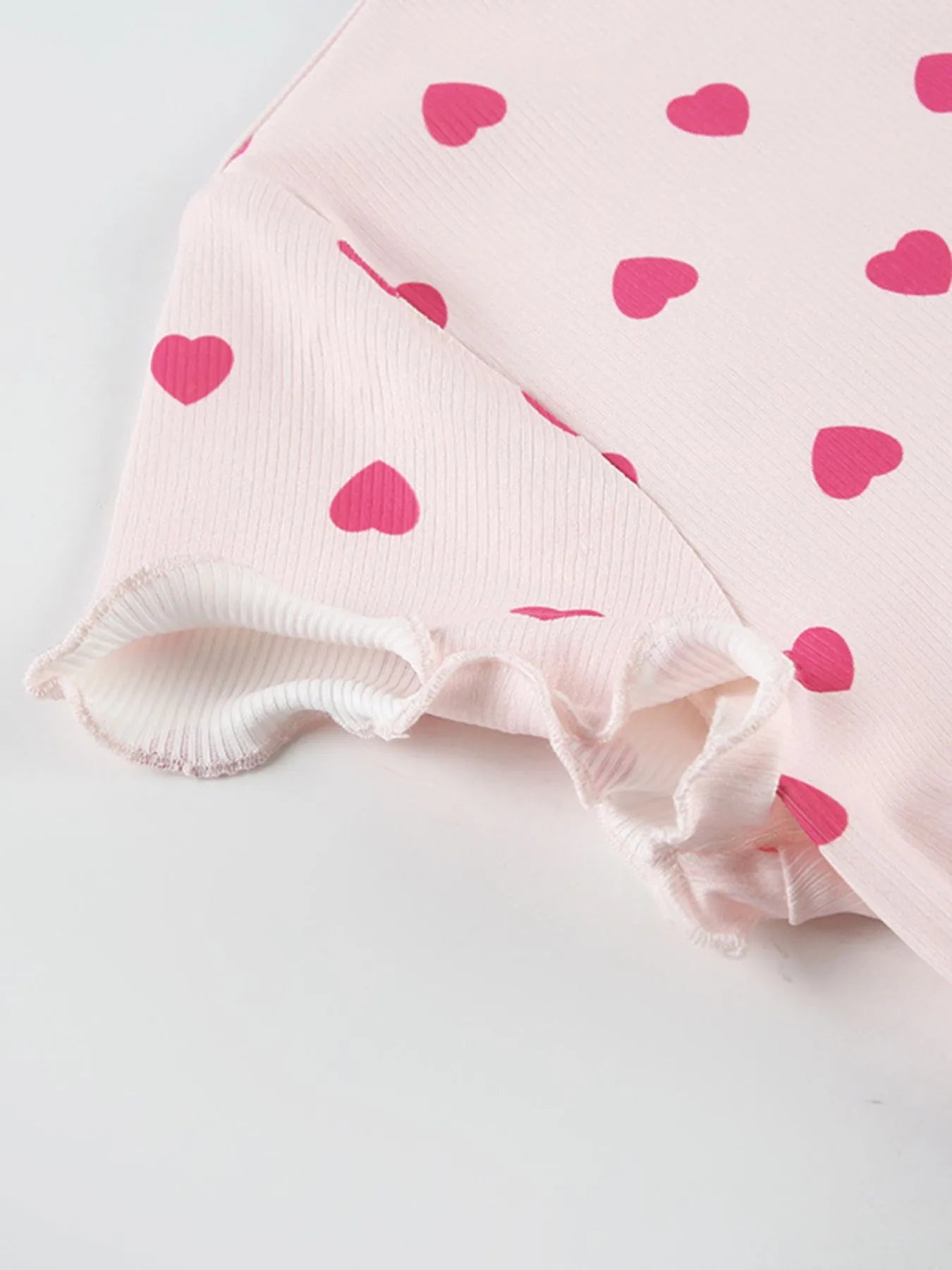Pink fabric with heart patterns on a light gray background