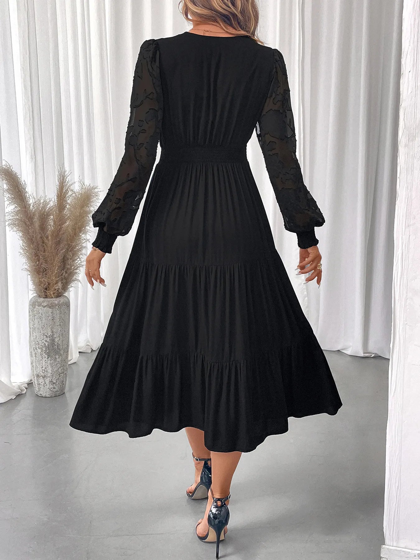 Back view of lace detail tiered dress with lantern sleeves