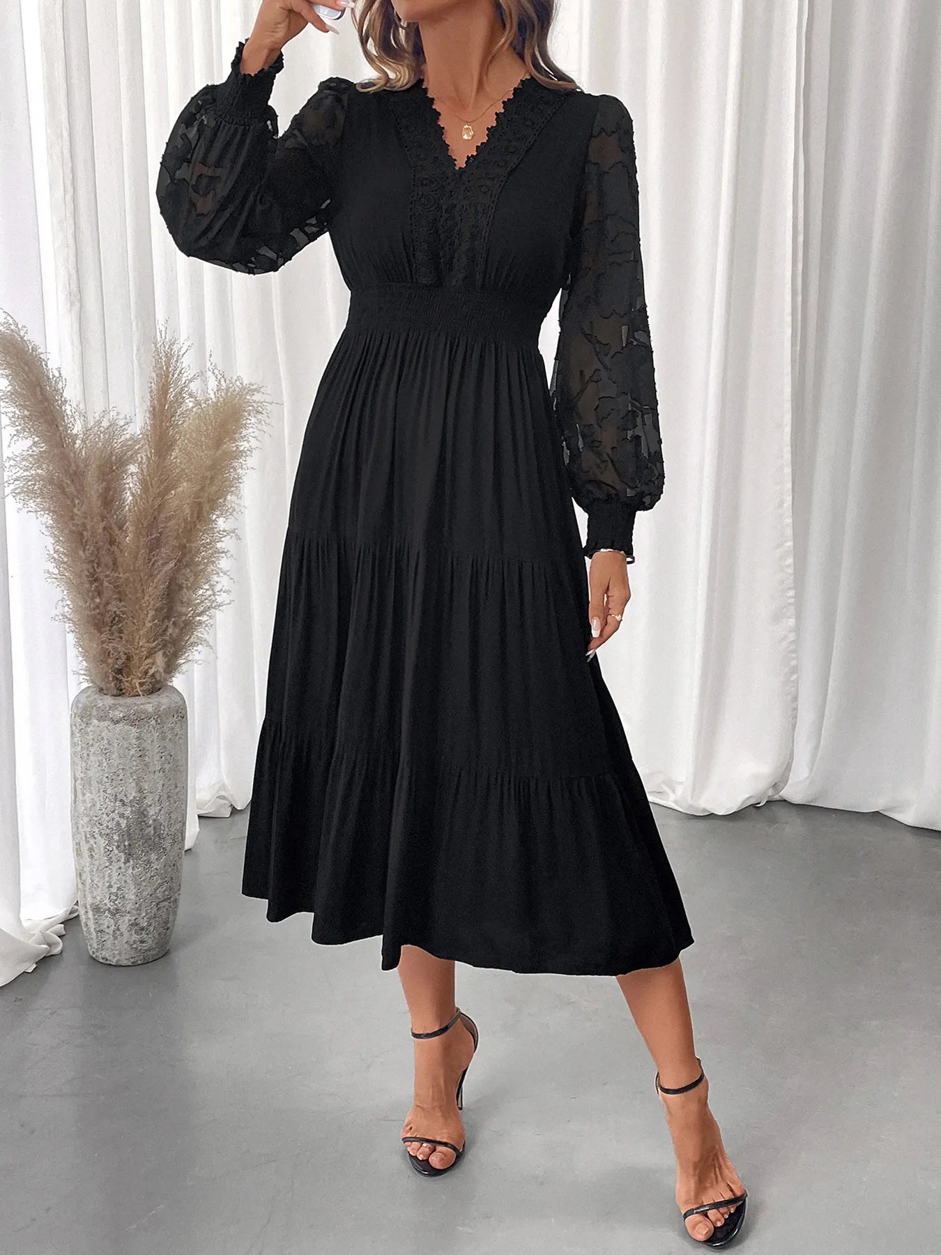 Model wearing lace detail lantern sleeve tiered dress at garden party