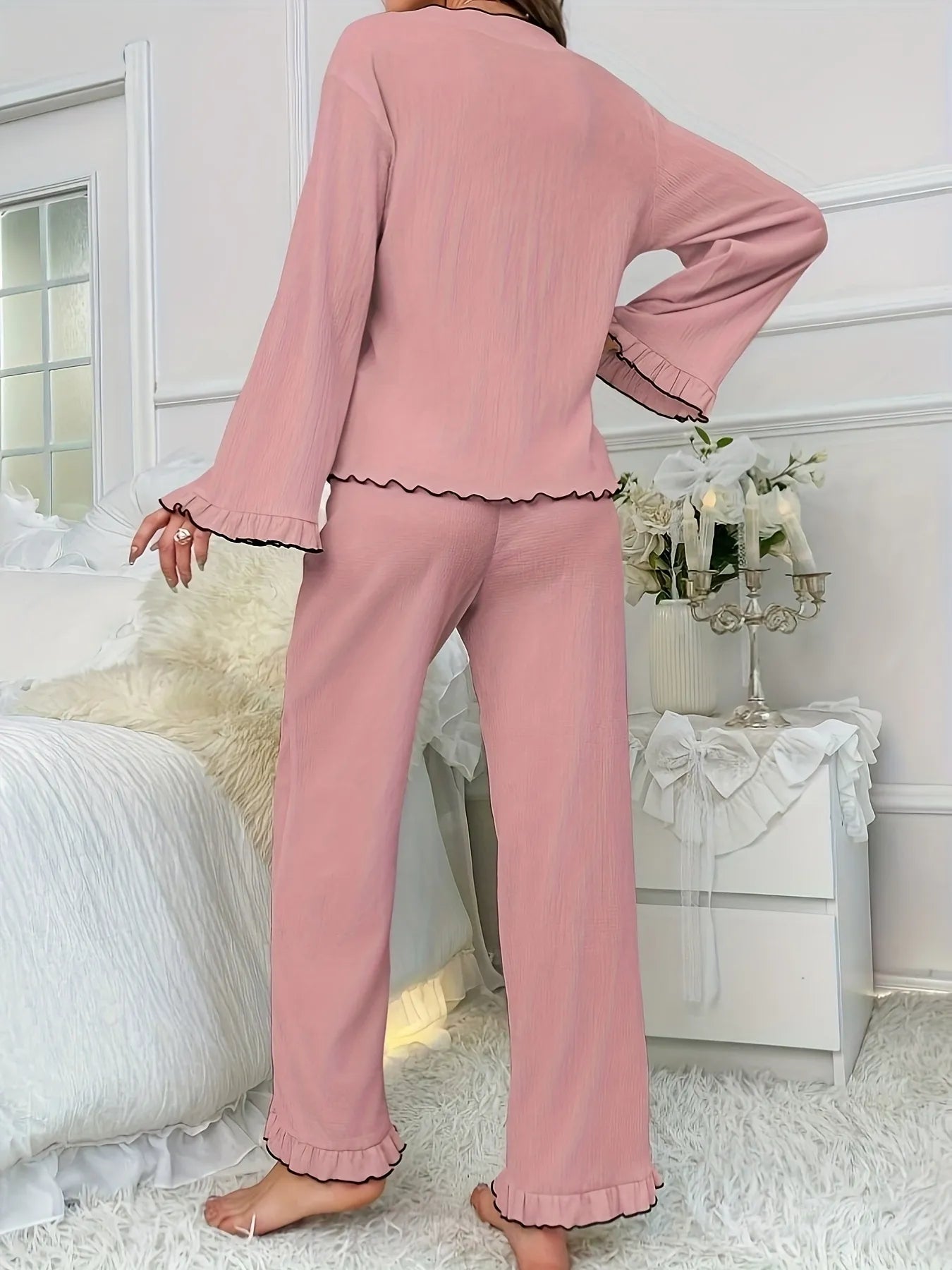 Person wearing pink pajamas in a bedroom setting